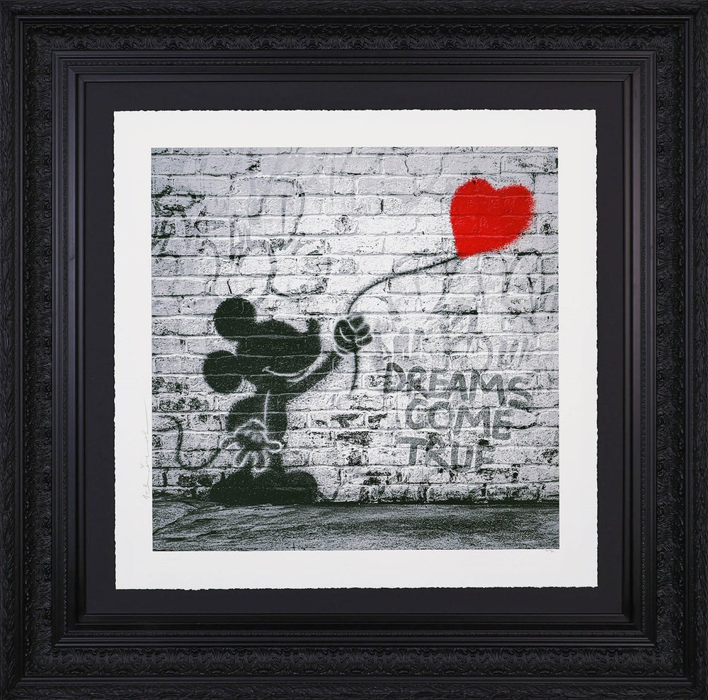 Black and white graffiti-style artwork by Mr. Brainwash depicting Mickey Mouse and a spray-painting of a red heart balloon on a brick wall. The phrase ‘DREAMS COME TRUE’ is stencilled beside him.
